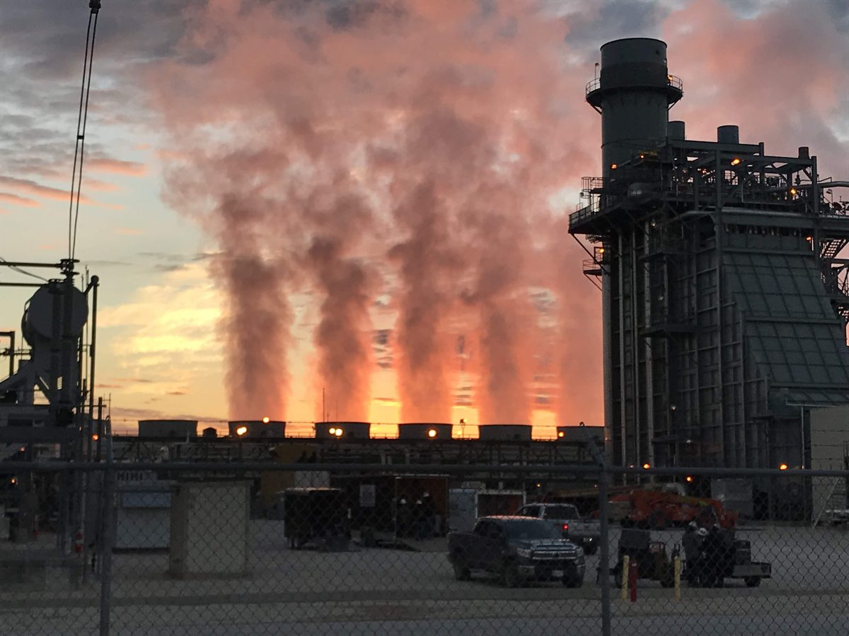 Power generation facility at sunset with steam plumes